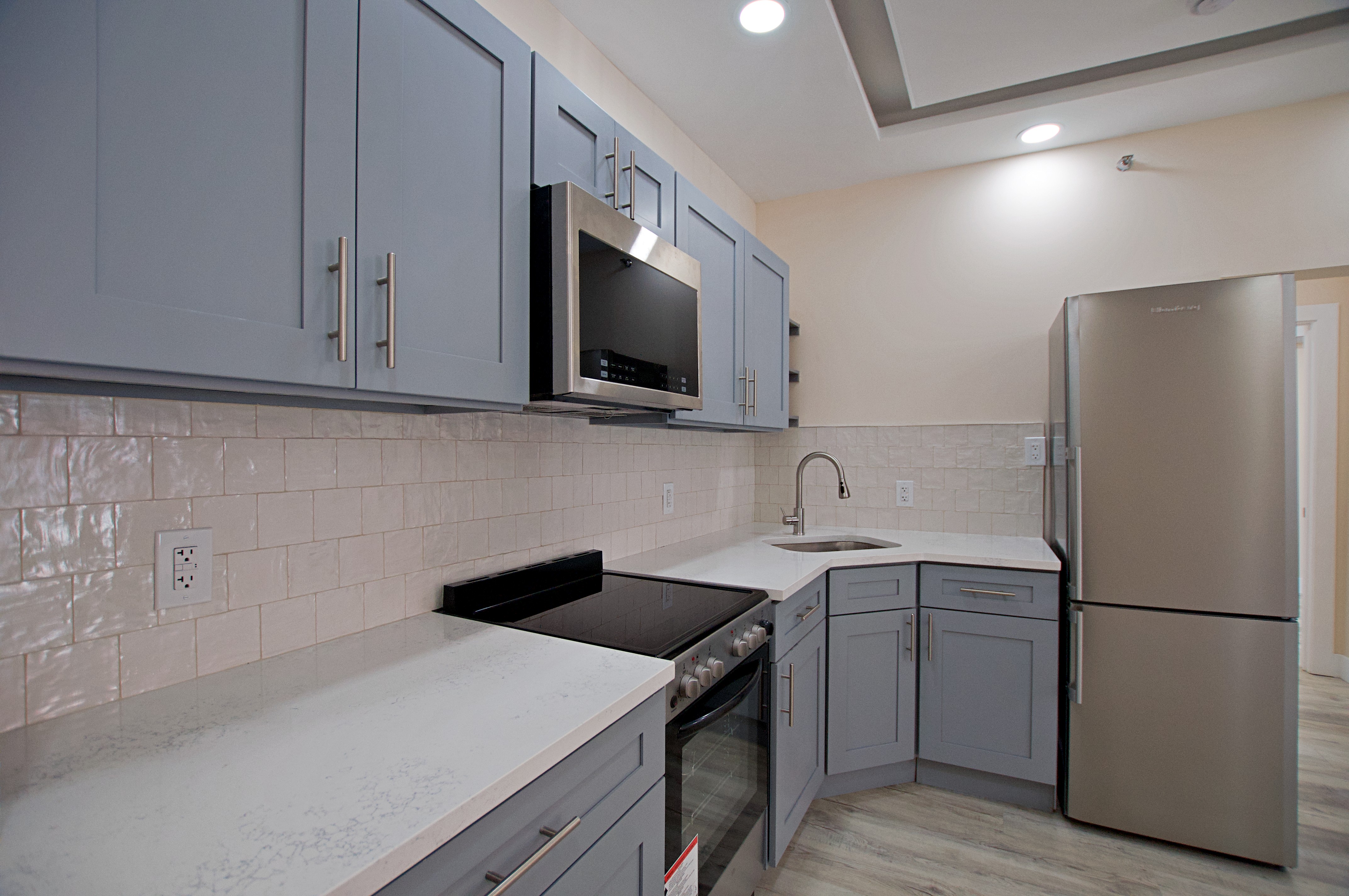 220 Madison Street, Unit 1A Brooklyn, NY 11216 - Photo 3 of 9 a kitchen with a sink a refrigerator and cabinets