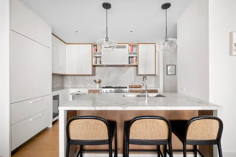 a view of kitchen island with stainless steel appliances granite countertop furniture a sink a refrigerator and window