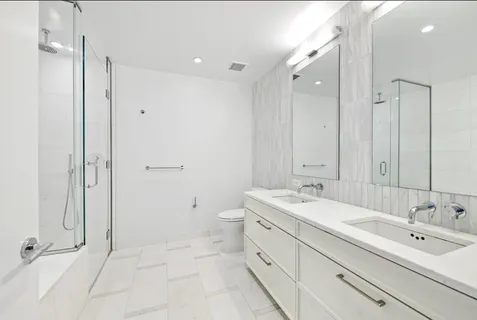 a spacious bathroom with a double vanity sink mirror and shower