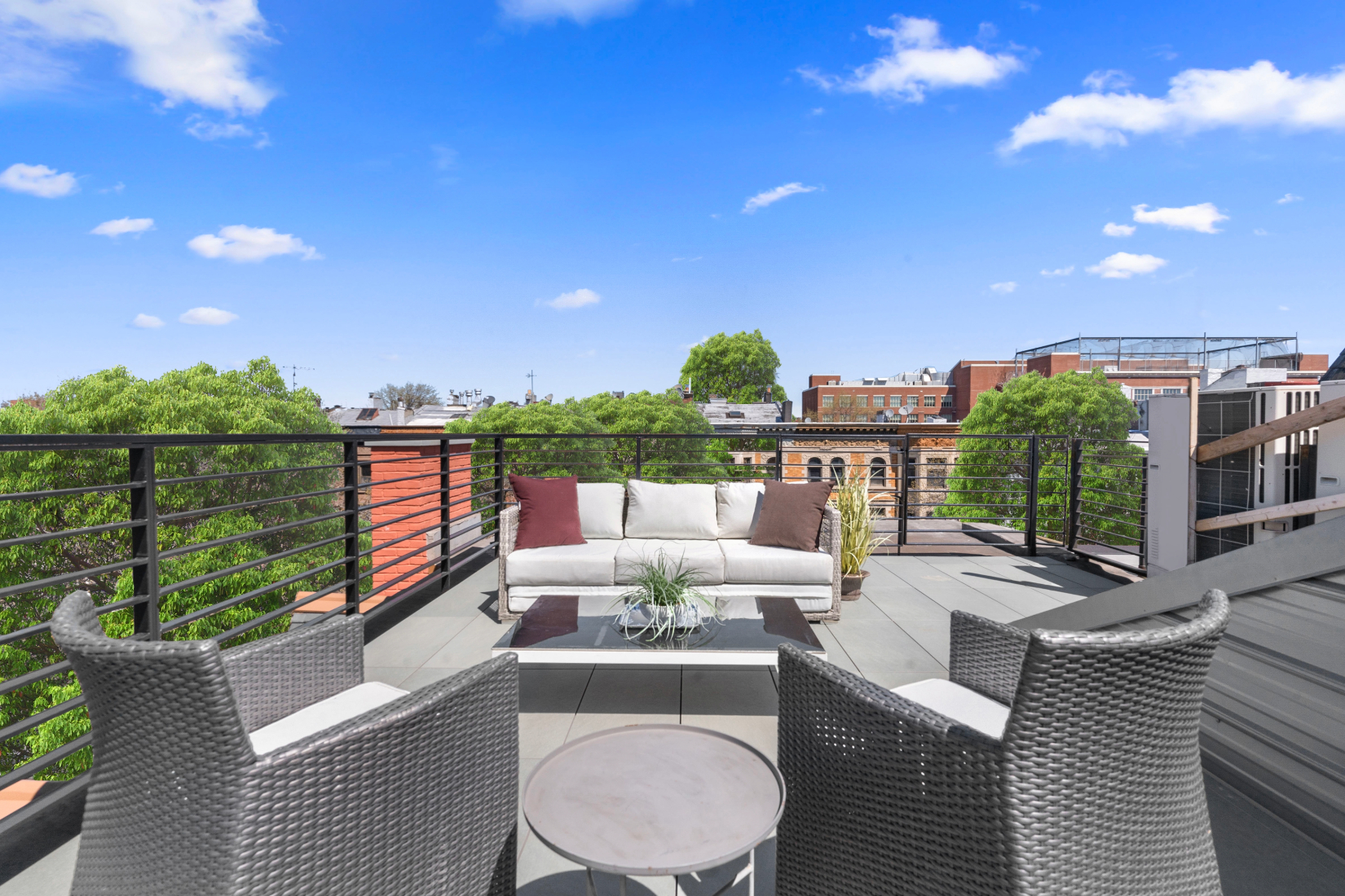 1370 Dean Street, Unit PHD Brooklyn, NY 11216 - Photo 10 of 12 a view of a patio with couches chairs potted plants and a palm tree