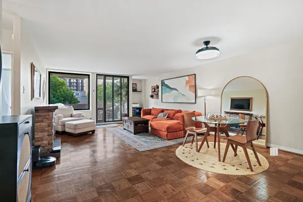 a living room with fireplace furniture and a large window