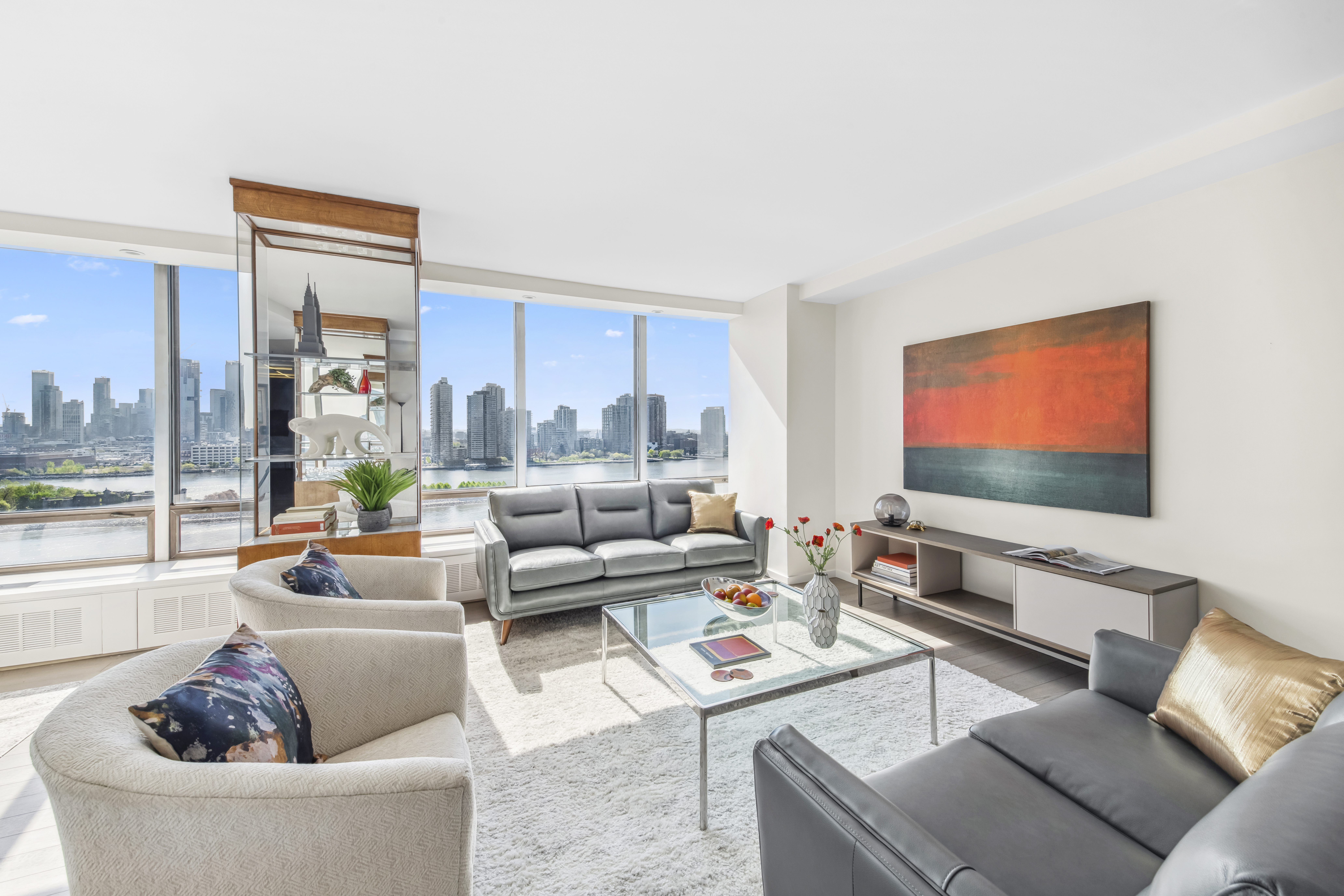 870 United Nations Plaza, Unit 15E Manhattan, NY 10017 - Photo 3 of 19 a living room with furniture and a flat screen tv