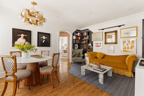 a living room with furniture a chandelier and a dining table