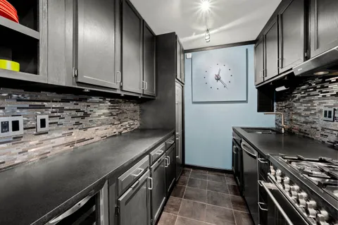 a kitchen with stainless steel appliances granite countertop a stove a sink and a microwave