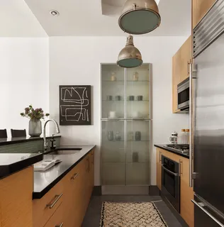 a kitchen with stainless steel appliances a sink a refrigerator and cabinets