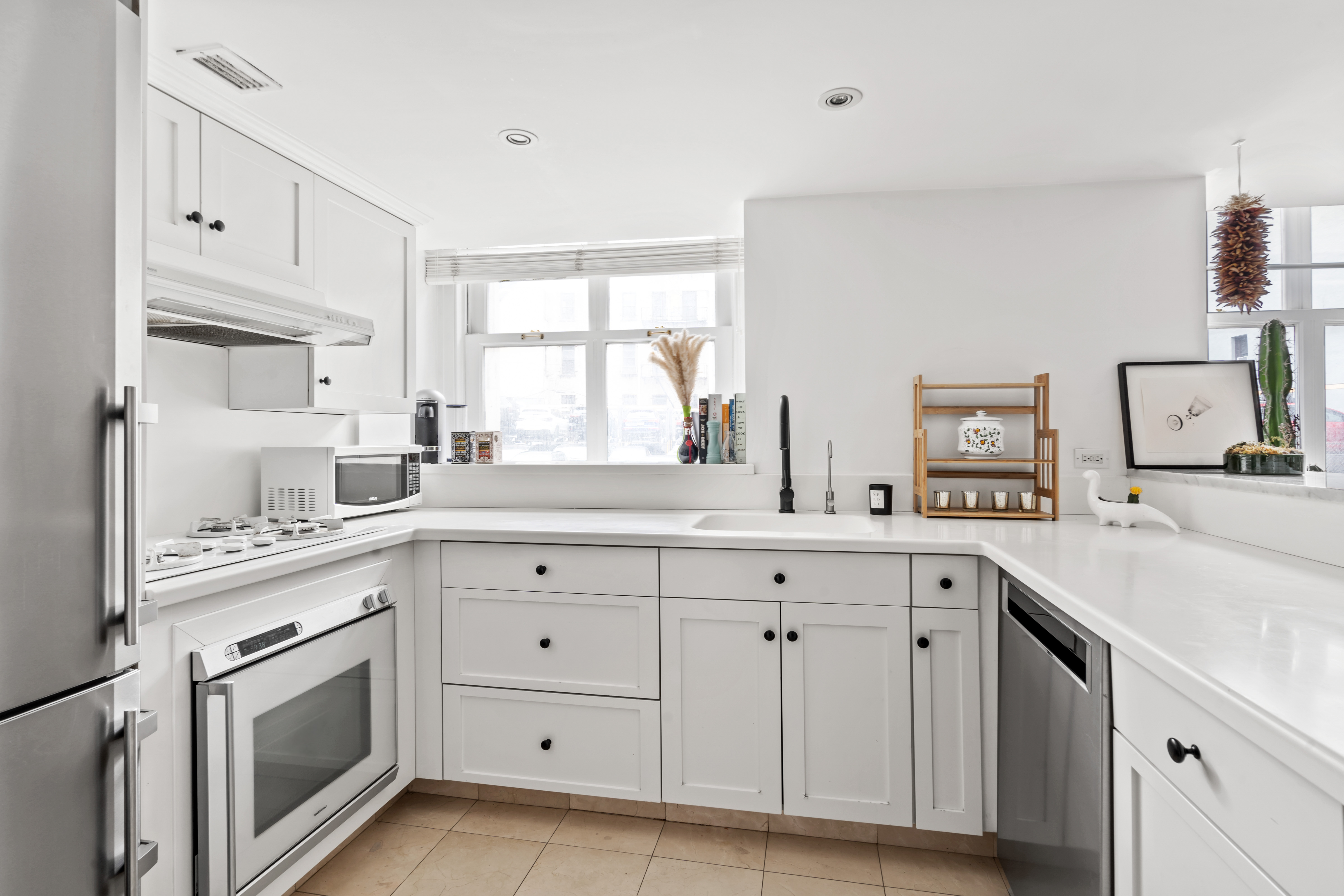 240 Centre Street, Unit 2N Manhattan, NY 10013 - Photo 6 of 16 a kitchen with cabinets appliances a sink and a window