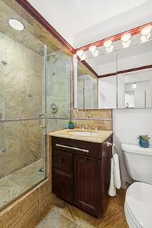 a bathroom with a sink a toilet and shower