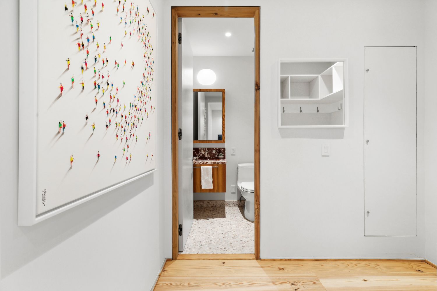 a view of a hallway with wooden floor and dining space
