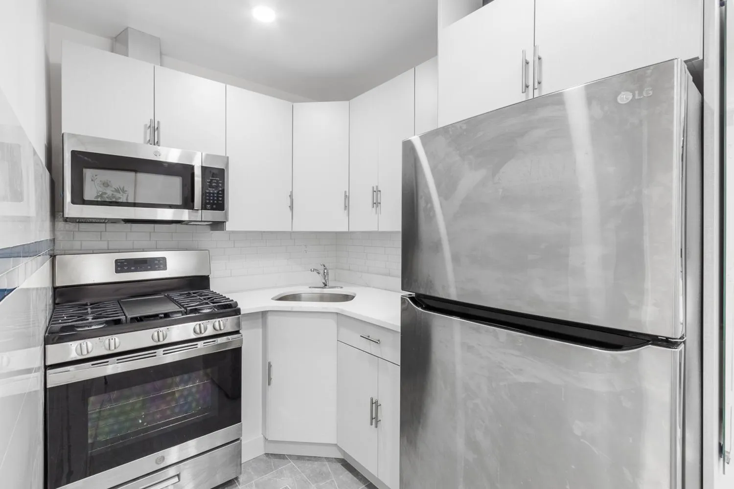a kitchen with white cabinets and stainless steel appliances