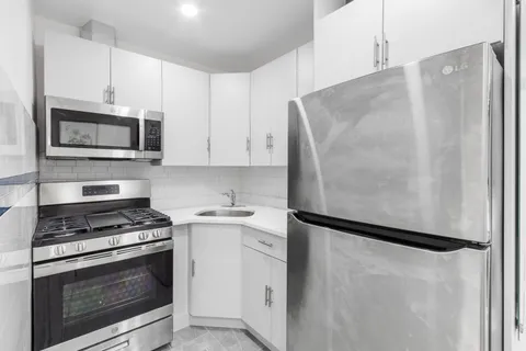 a kitchen with white cabinets and stainless steel appliances