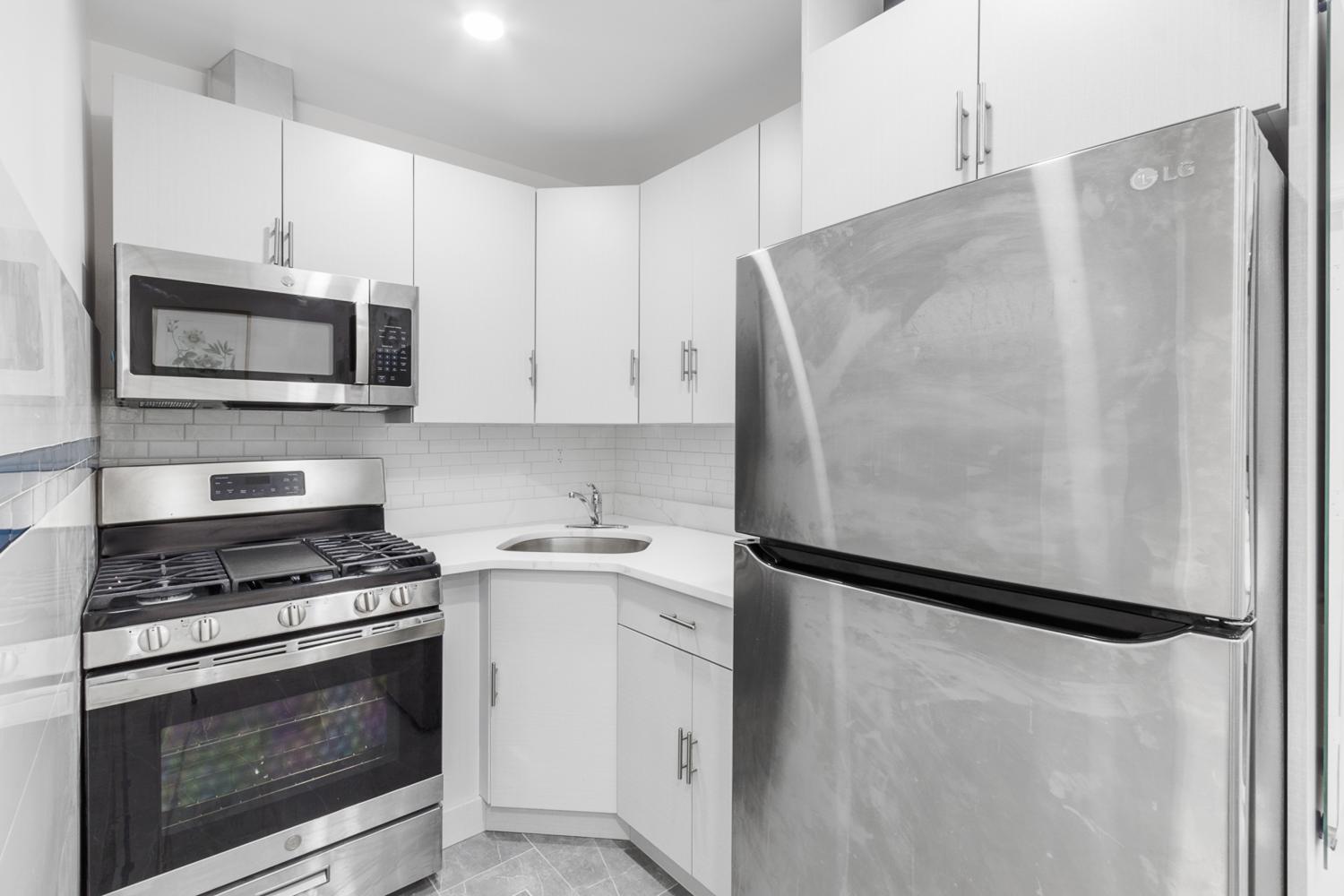a kitchen with white cabinets and stainless steel appliances