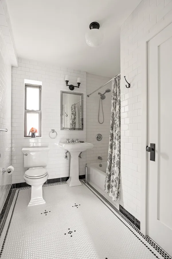 a bathroom with a toilet sink a mirror and shower