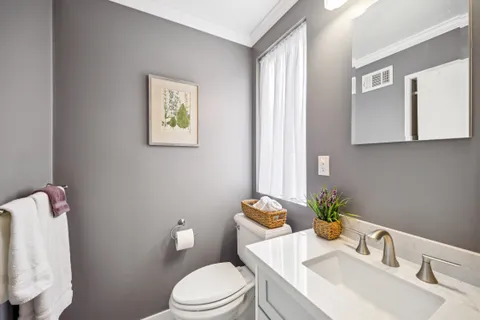 a white toilet sitting next to a bathroom sink