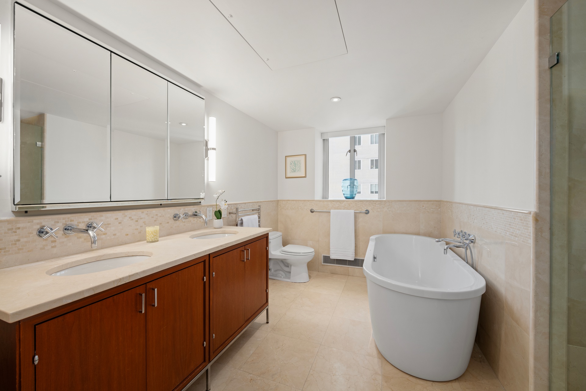 200 East 66th Street, Unit D1205 Manhattan, NY 10065 - Photo 9 of 33 a bathroom with a tub sink and mirror