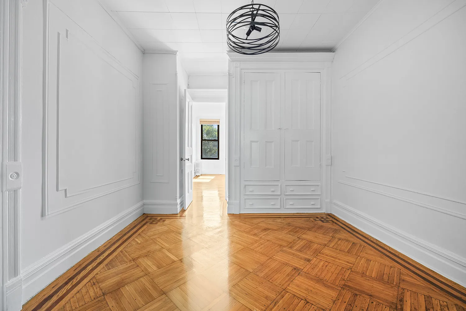 a view of empty room with wooden floor