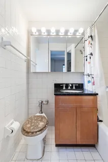 a bathroom with a granite countertop sink a toilet and a mirror