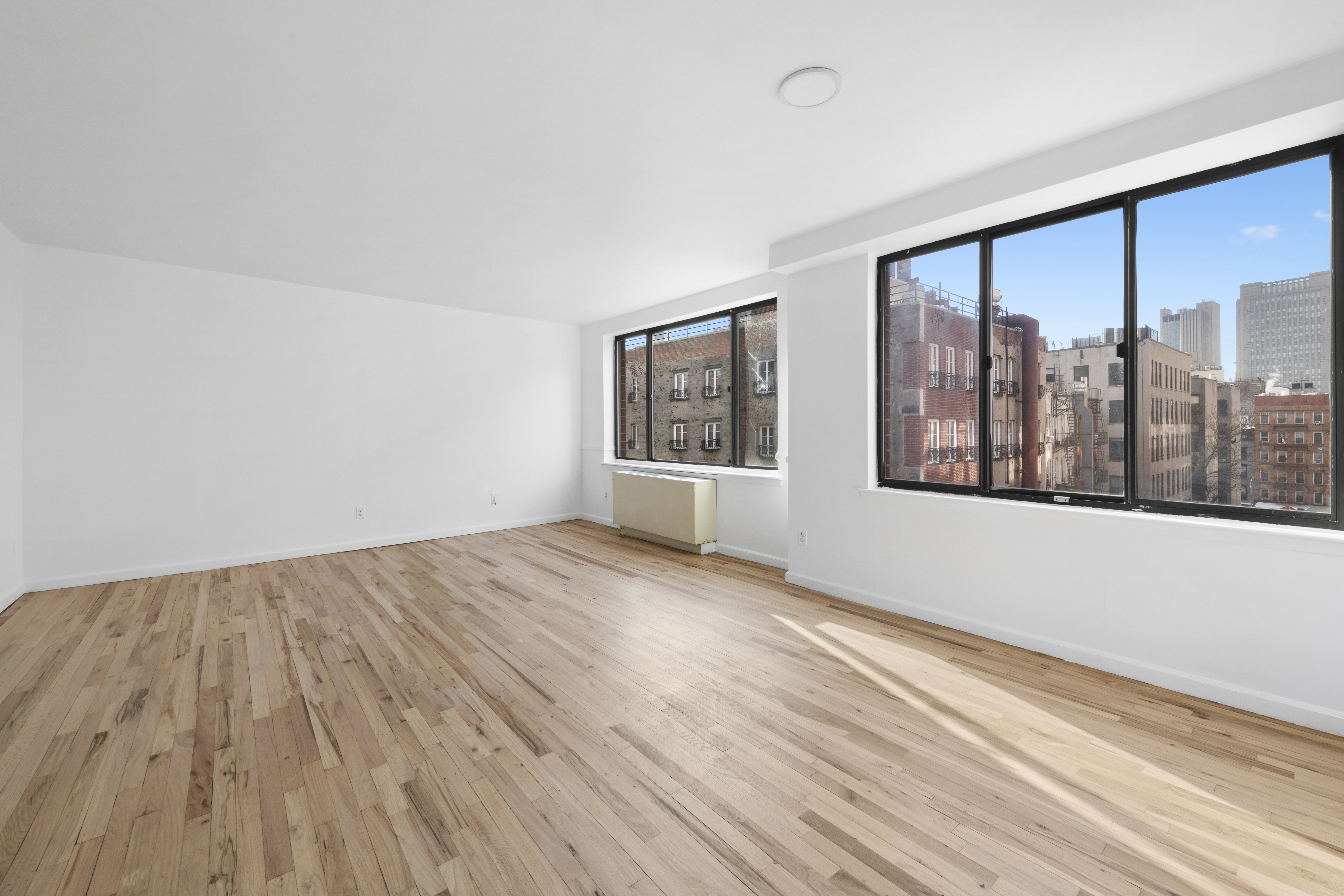 179 Grand Street, Unit 6G Manhattan, NY 10013 - Photo 1 of 8 wooden floor in an empty room with a window