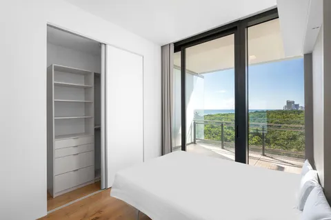 a bedroom with a bed and a large window