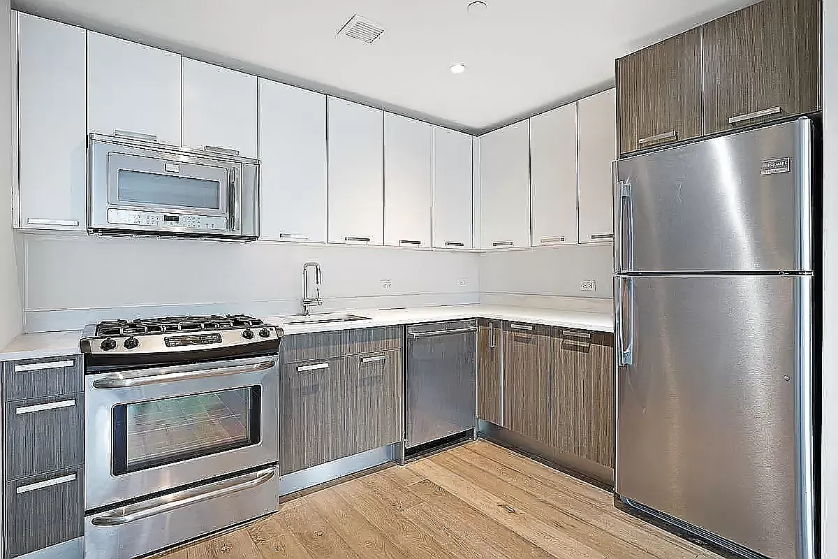 26-14 Jackson Avenue, Unit 9BB Queens, NY 11101 - Photo 2 of 8 a kitchen with stainless steel appliances granite countertop a stove a refrigerator and a microwave