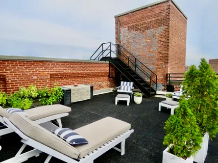 a view of a patio with lawn chairs next to a yard