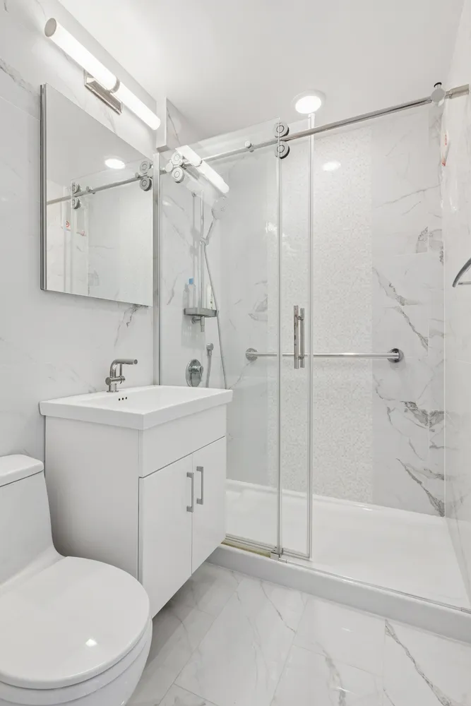 a bathroom with a sink mirror and a shower