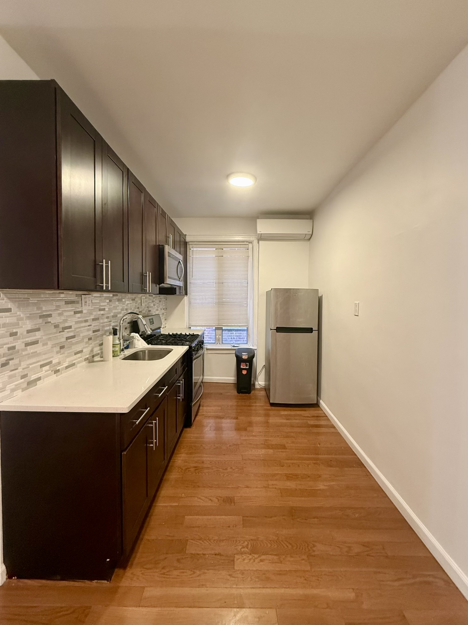 18-48 21st Drive, Unit 1R Queens, NY 11105 - Photo 7 of 11 a large kitchen with a stove and a refrigerator