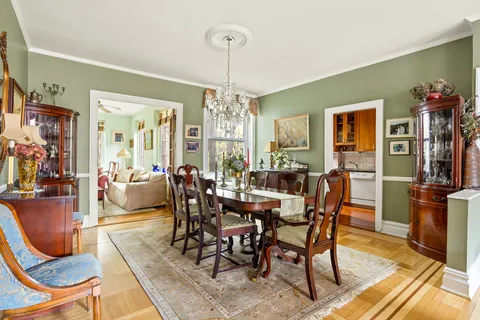 a view of a dining room with furniture a chandelier and wooden floor