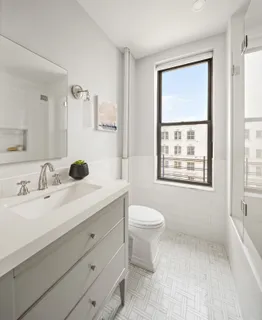 a bathroom with a granite countertop sink mirror vanity and toilet