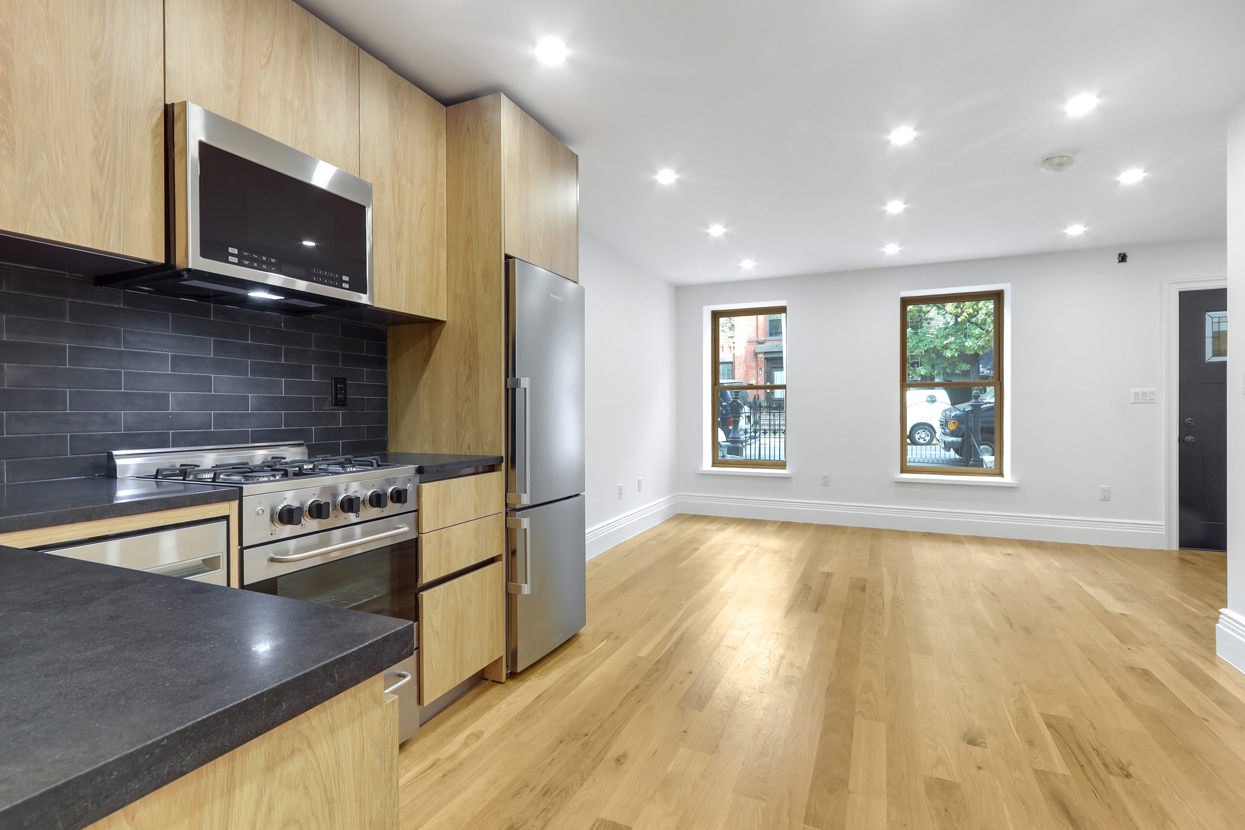 220 Lewis Avenue Brooklyn, NY 11221 - Photo 19 of 22 a kitchen with stainless steel appliances granite countertop a stove and a microwave