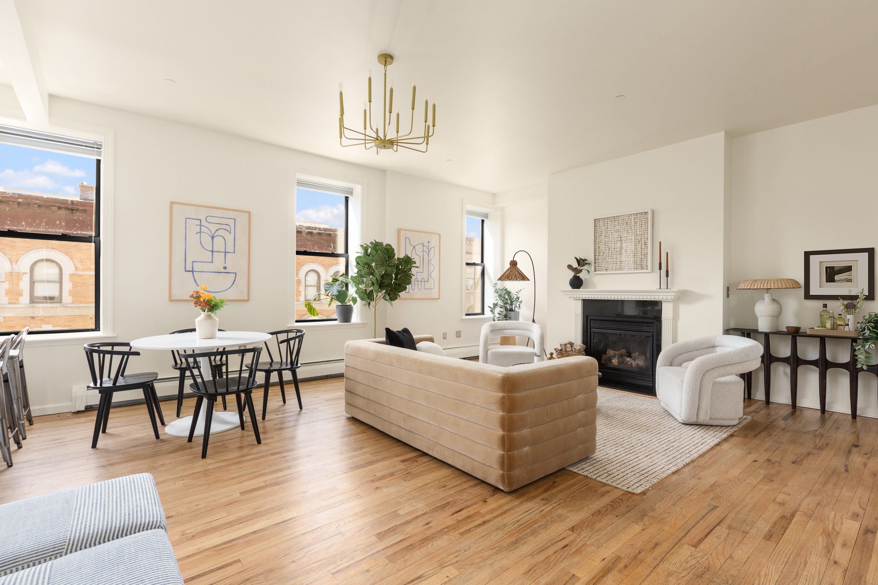 a living room with furniture a fireplace and a dining table with wooden floor