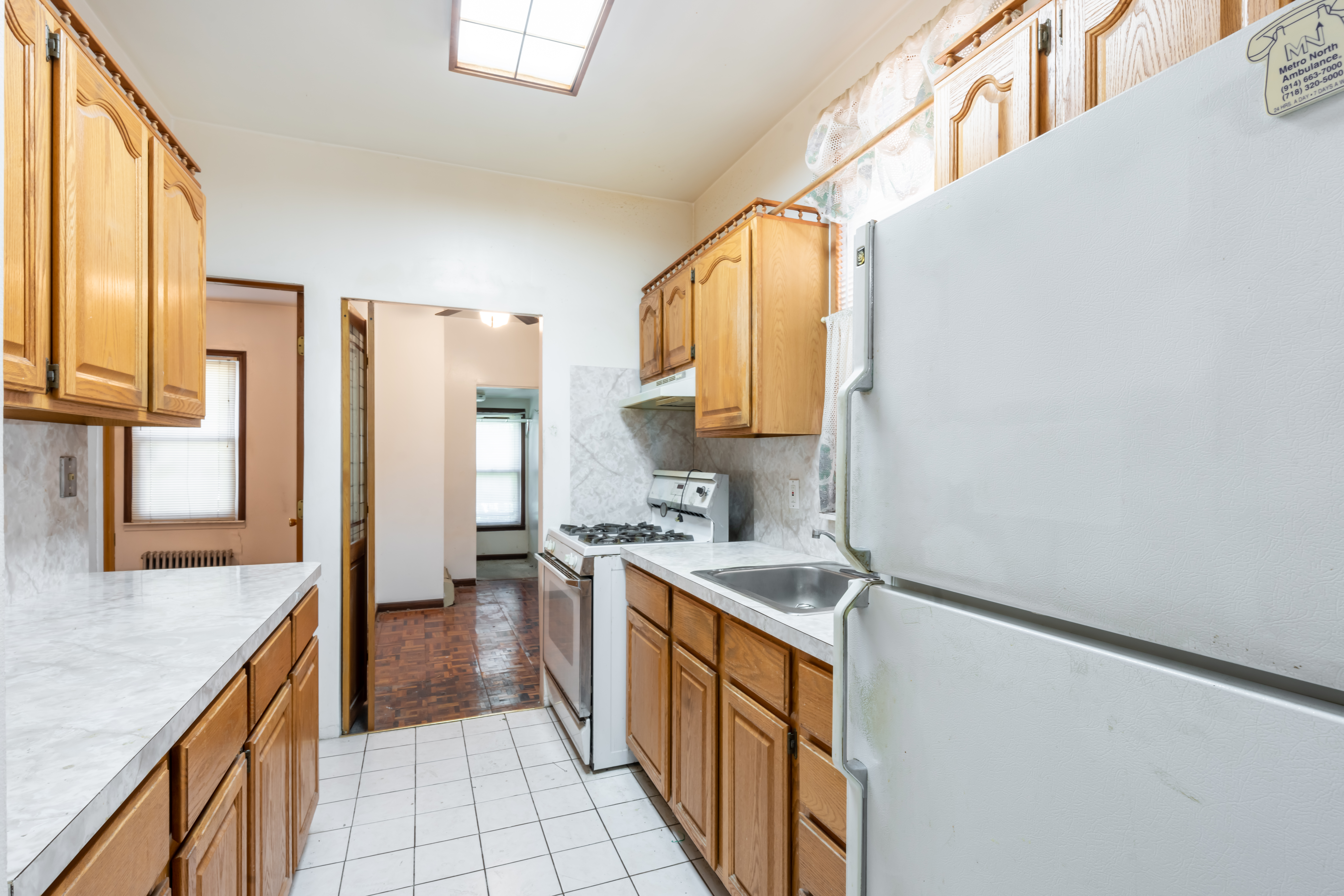 1085 Arnow Avenue Bronx, NY 10469 - Photo 5 of 16 a kitchen with stainless steel appliances granite countertop a sink and a refrigerator