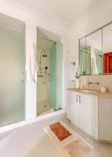 a spacious bathroom with a shower sink and mirror