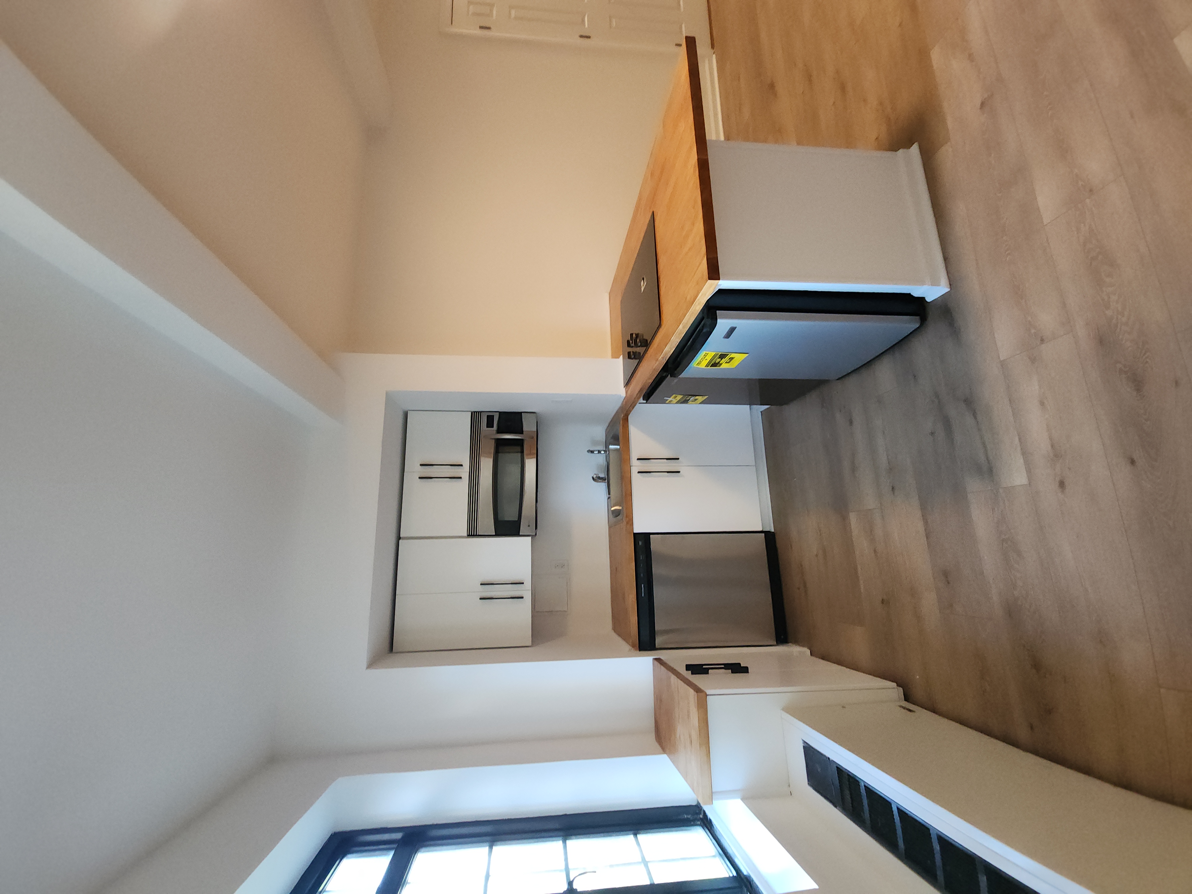 5 Tudor City Place, Unit 602 Manhattan, NY 10017 - Photo 11 of 20 a large kitchen with a stove top oven and white cabinets