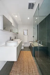 a large white kitchen with a sink and large mirror