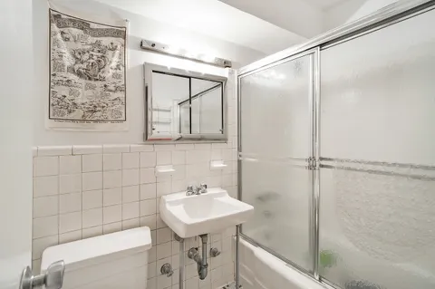 a bathroom with a sink and mirror with bathtub