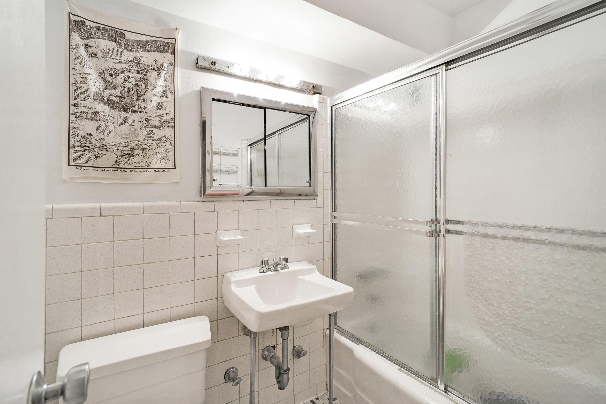 142 East 16th Street, Unit 7G Manhattan, NY 10003 - Photo 4 of 9 a bathroom with a sink and mirror with bathtub