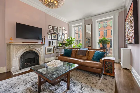 a living room with furniture a flat screen tv and a fireplace