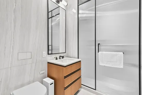 a bathroom with a sink a toilet and shower