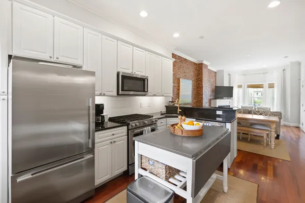 a kitchen with stainless steel appliances granite countertop a refrigerator a stove and a sink