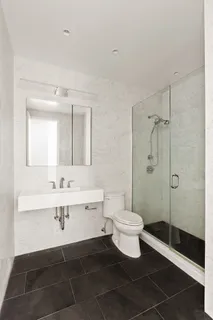 a bathroom with a sink a toilet a mirror and shower