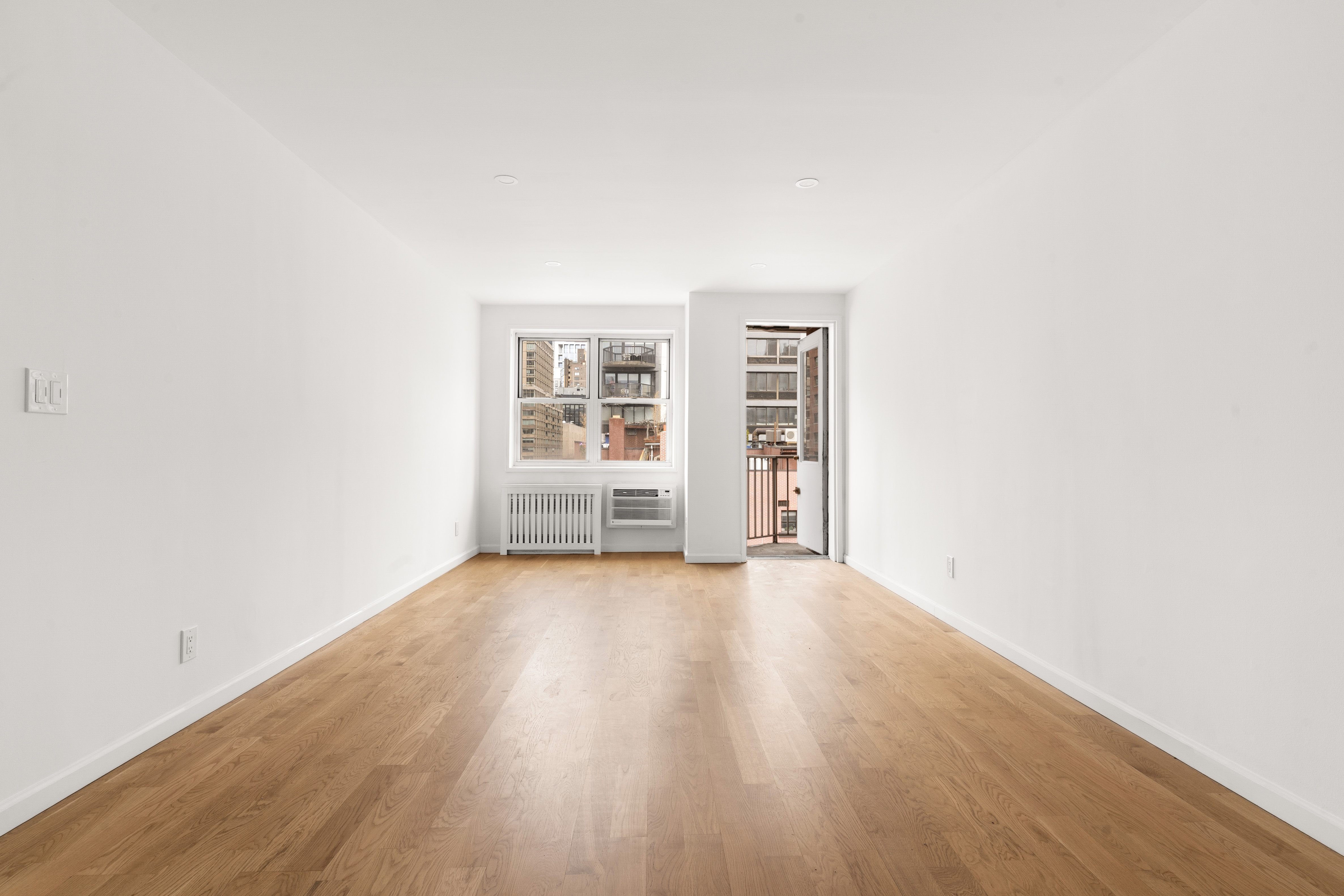 170 West 23rd Street, Unit 5N Manhattan, NY 10011 - Photo 2 of 17 an empty room with wooden floor and windows