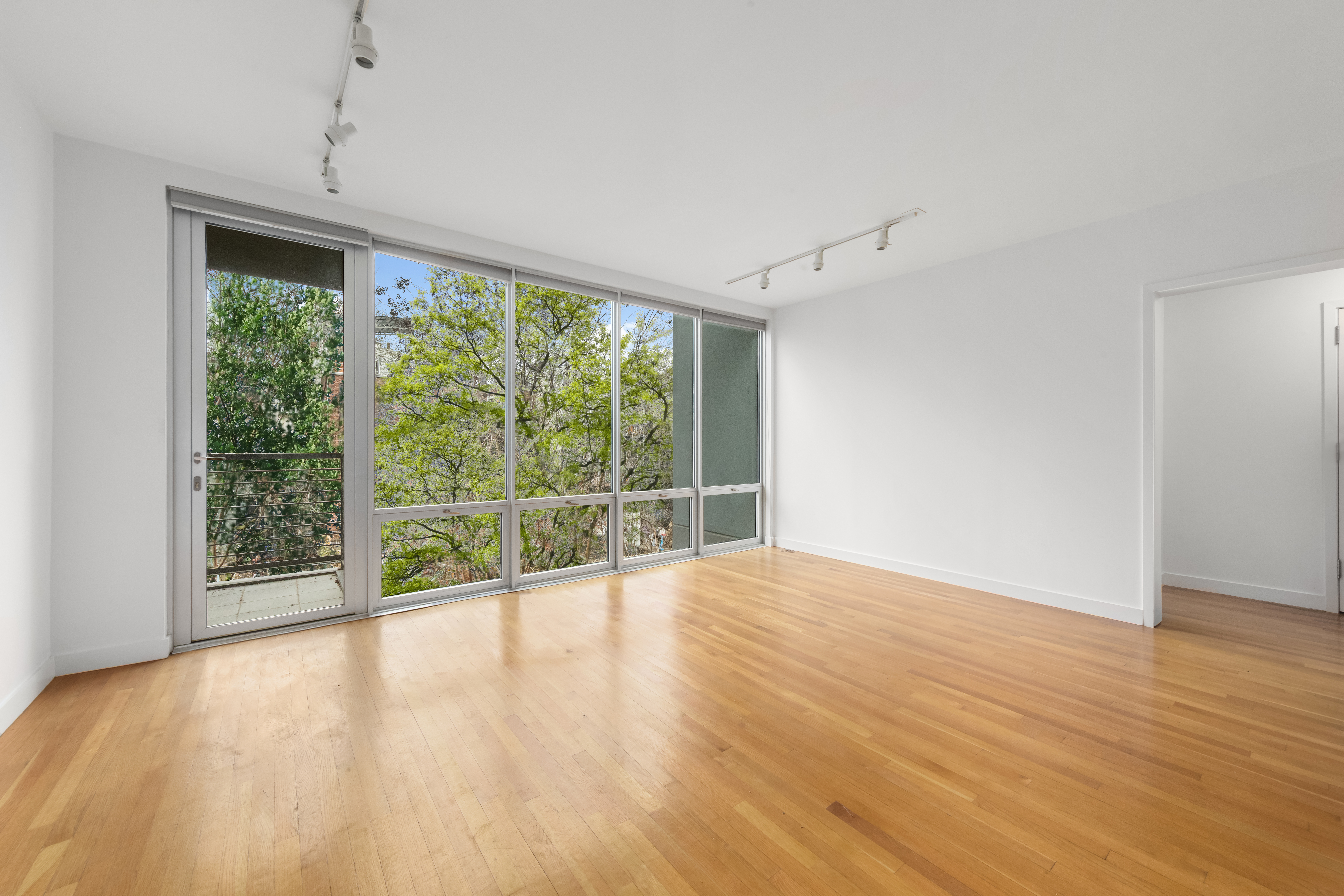 232 7th Street, Unit 3B Brooklyn, NY 11215 - Photo 3 of 7 a view of an empty room with wooden floor and a window