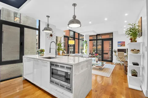 a kitchen with stainless steel appliances granite countertop a stove and a large window