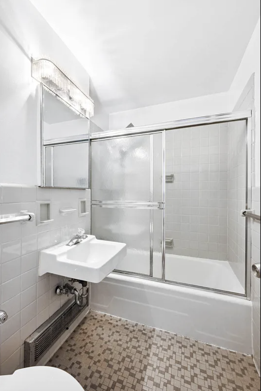 77 West 55th Street, Unit 11G Manhattan, NY 10019 - Photo 5 of 12 a bathroom with a sink toilet a mirror and shower