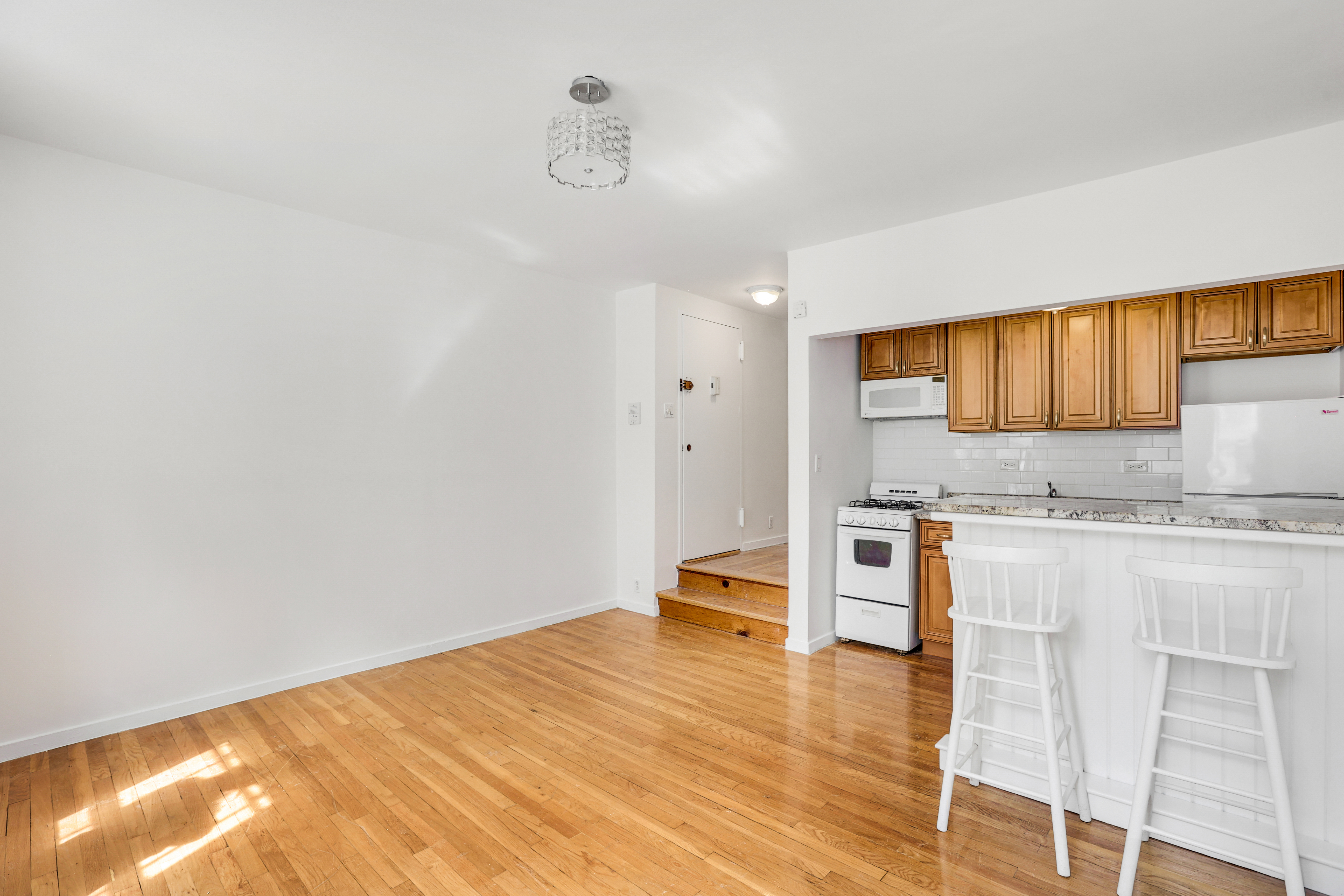 141 West 94th Street, Unit 1F Manhattan, NY 10025 - Photo 3 of 9 a kitchen with a wooden floor and cabinets