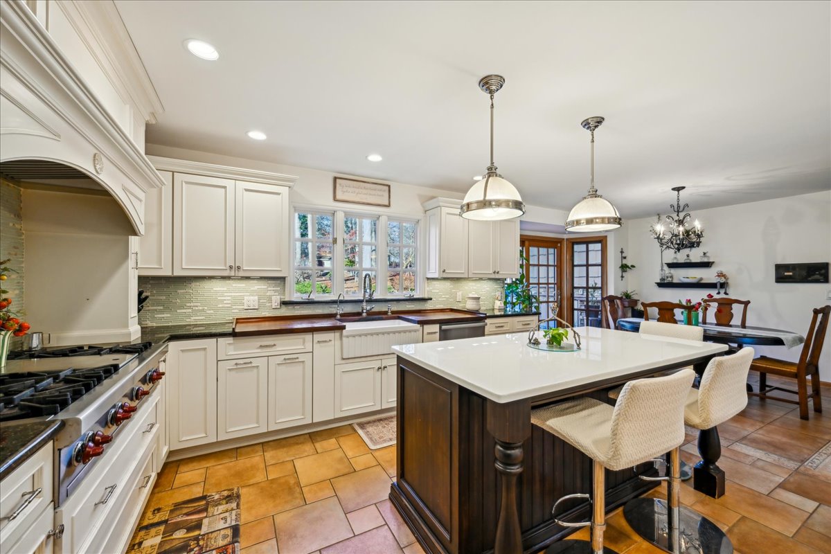 Johnston Drive Watchung, NJ 07069 - Photo 29 of 85 a kitchen with stainless steel appliances kitchen island granite countertop a stove a sink a dining table and chairs with wooden floor