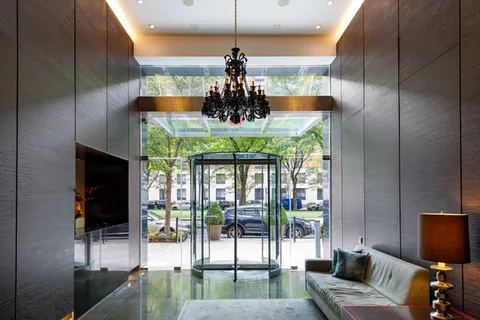 a dining room with furniture water view and a floor to ceiling window