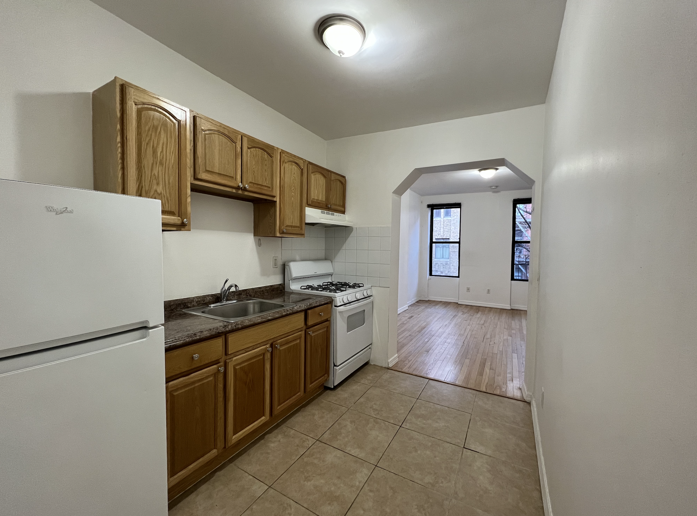 446 West 46th Street, Unit 5 Manhattan, NY 10036 - Photo 8 of 15 a kitchen with stainless steel appliances granite countertop a stove a sink and a refrigerator