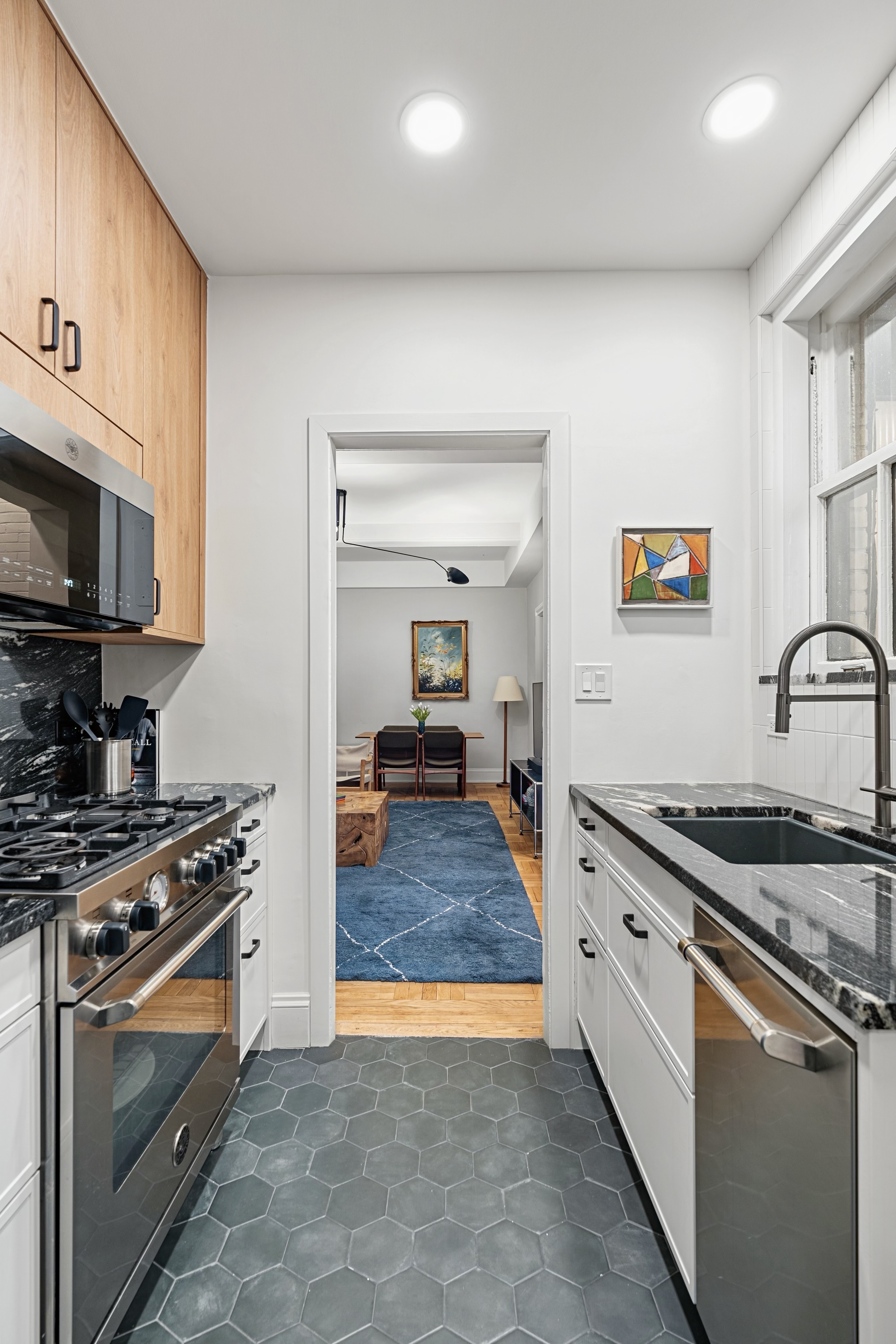 40 West 67th Street, Unit 1A Manhattan, NY 10023 - Photo 5 of 17 a kitchen with stainless steel appliances granite countertop a stove and a sink