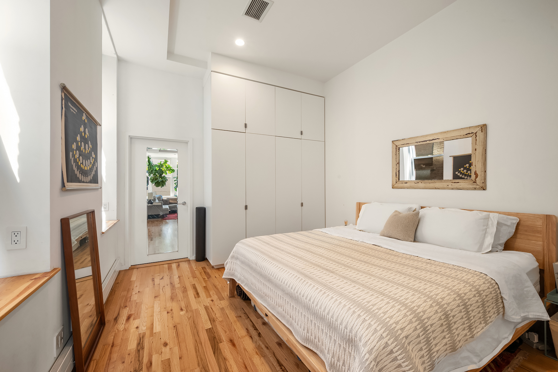 175 East Broadway, Unit 4C Manhattan, NY 10002 - Photo 7 of 14 a bedroom with a bed and a wooden floor